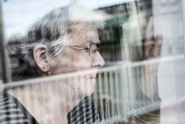 Senior looking out window - managing memory loss at home