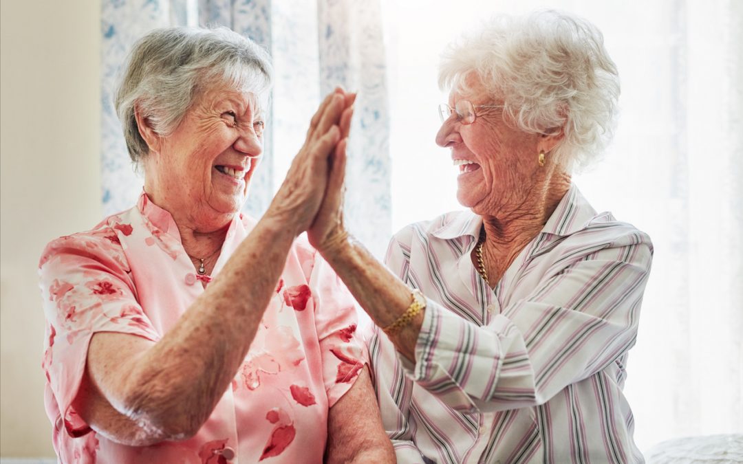 two senior women giving high fives