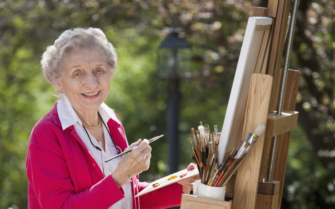 senior woman outdoors painting smiling